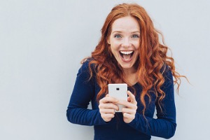 Excited Woman with Mobile Phone In Hand